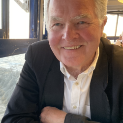 Eldre mann i dress og kvit skjorte