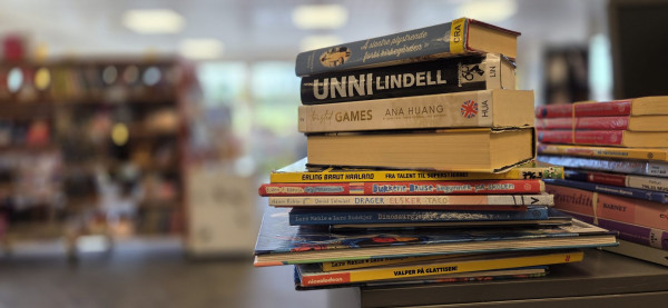 bøker i ein bunke i eit bibliotekmiljø